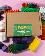 Mellow Fidgets Pain Stim Mystery Box containing four random 3D printed spiky sensory fidget toys in assorted colours and textures.